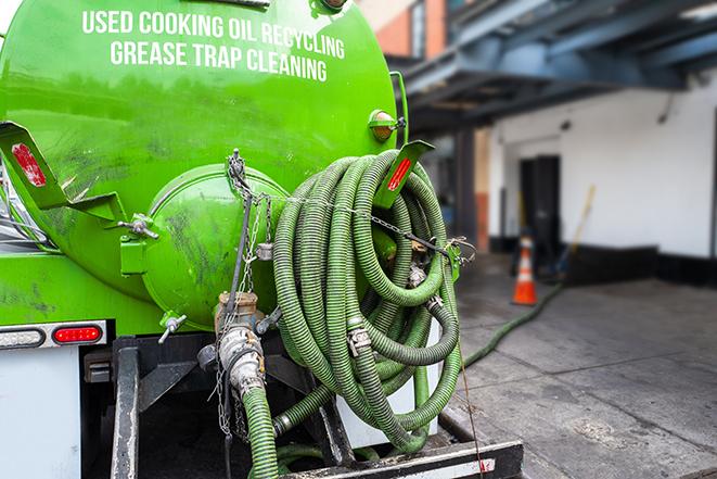 a technician pumping a grease trap in a commercial building in Newport Beach